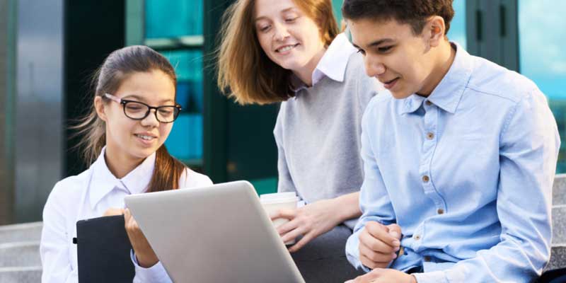 Image: 3 year 10 students reading a story on a laptop. Image: 3 year 10 students reading a story on a laptop.