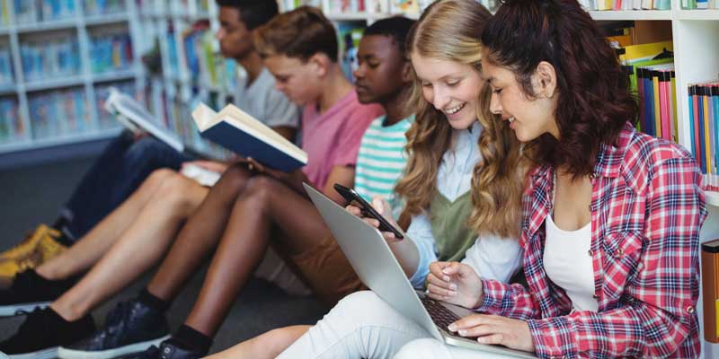 A group of year 9 and 10 students reading and writing in the library. A group of year 9 and 10 students reading and writing in the library.