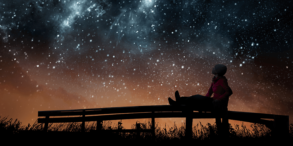 Image: A GIrl sitting on a bench, gazing at the sky. Image: A GIrl sitting on a bench, gazing at the sky.