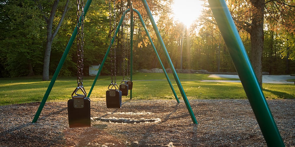 Image: Swings in a lovely park. The sun is setting. Image: Swings in a lovely park. The sun is setting.